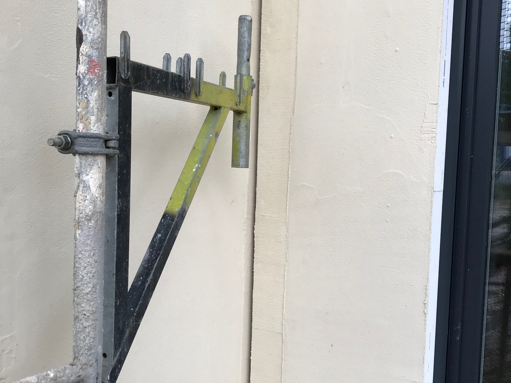 Außenwand mit Baugerüst und Fensterfront einer Baustelle an der Fassade