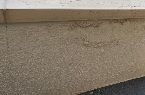 Aussenwand mit rauer Putzoberflaeche und sichtbaren BauMaengeln