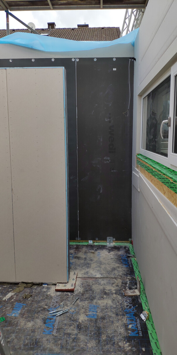 Außenwand mit Dämmung und Baukonstruktion, Fensterrahmen sichtbar, Bauarbeiten