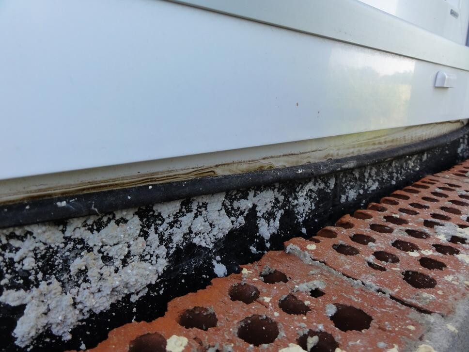 Nahaufnahme unterer Außenwand mit Schimmel am Fundament
