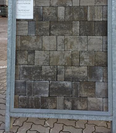 Außenwand-Verkleidung aus dunklen Steinquadern im Metallrahmen