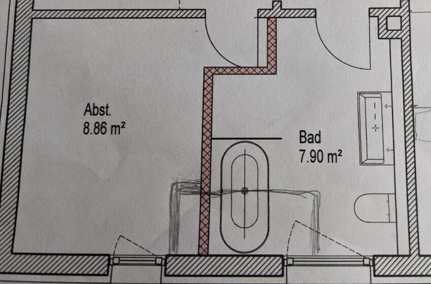 Grundriss eines Badezimmers mit Badewanne, Waschbecken und Abstellraum.