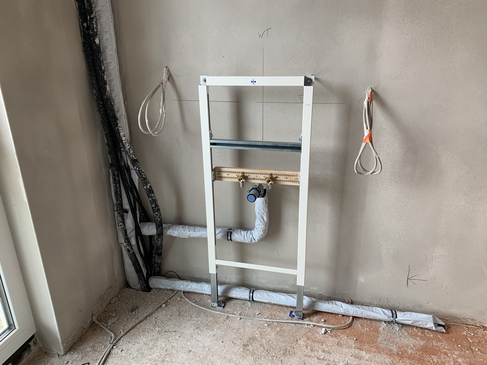 Weißer Installationsrahmen für wandhängende Toilette mit Abflussrohr und Wasseranschlüssen.