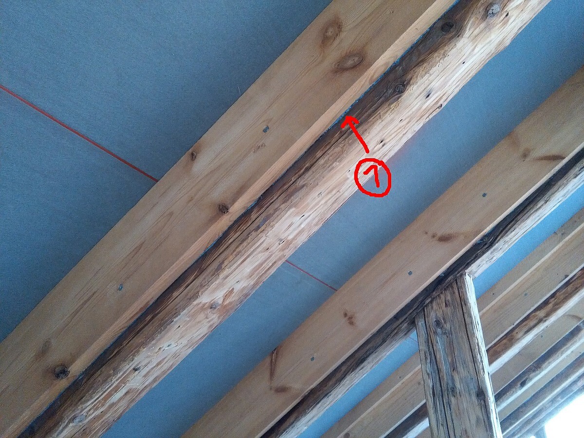 Holzträger im Rohbau mit markierter Defektstelle