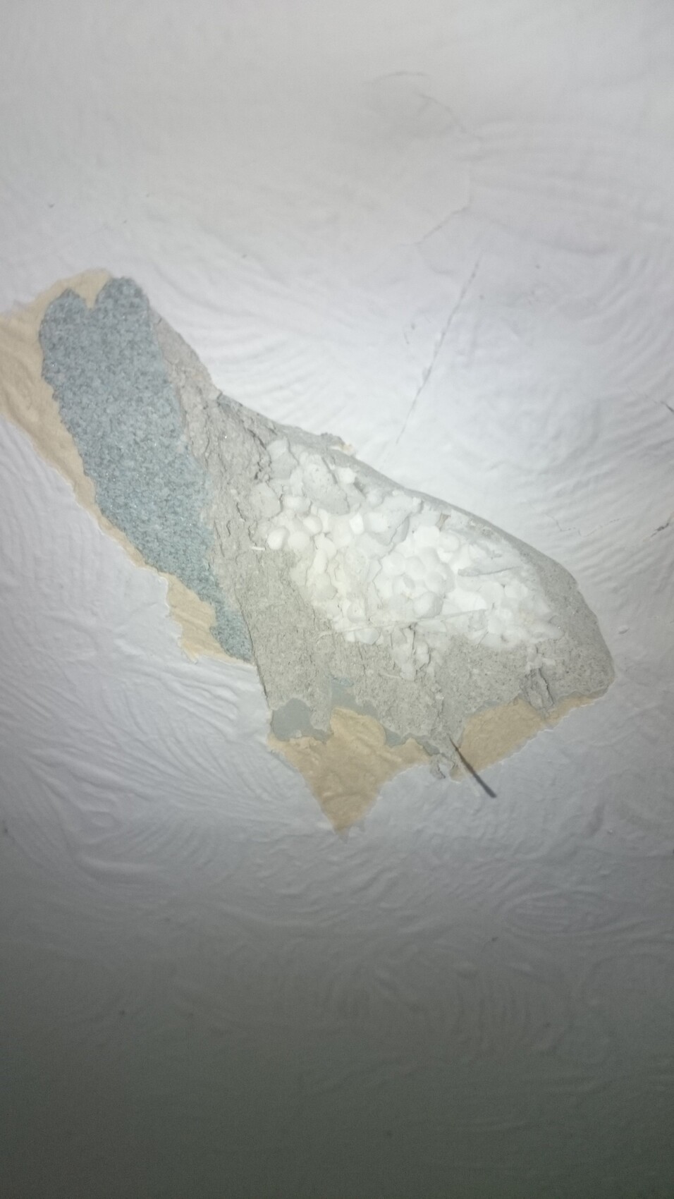 Bruchstück Deckenverputzung mit mehreren Putzschichten und grober, poröser Struktur.