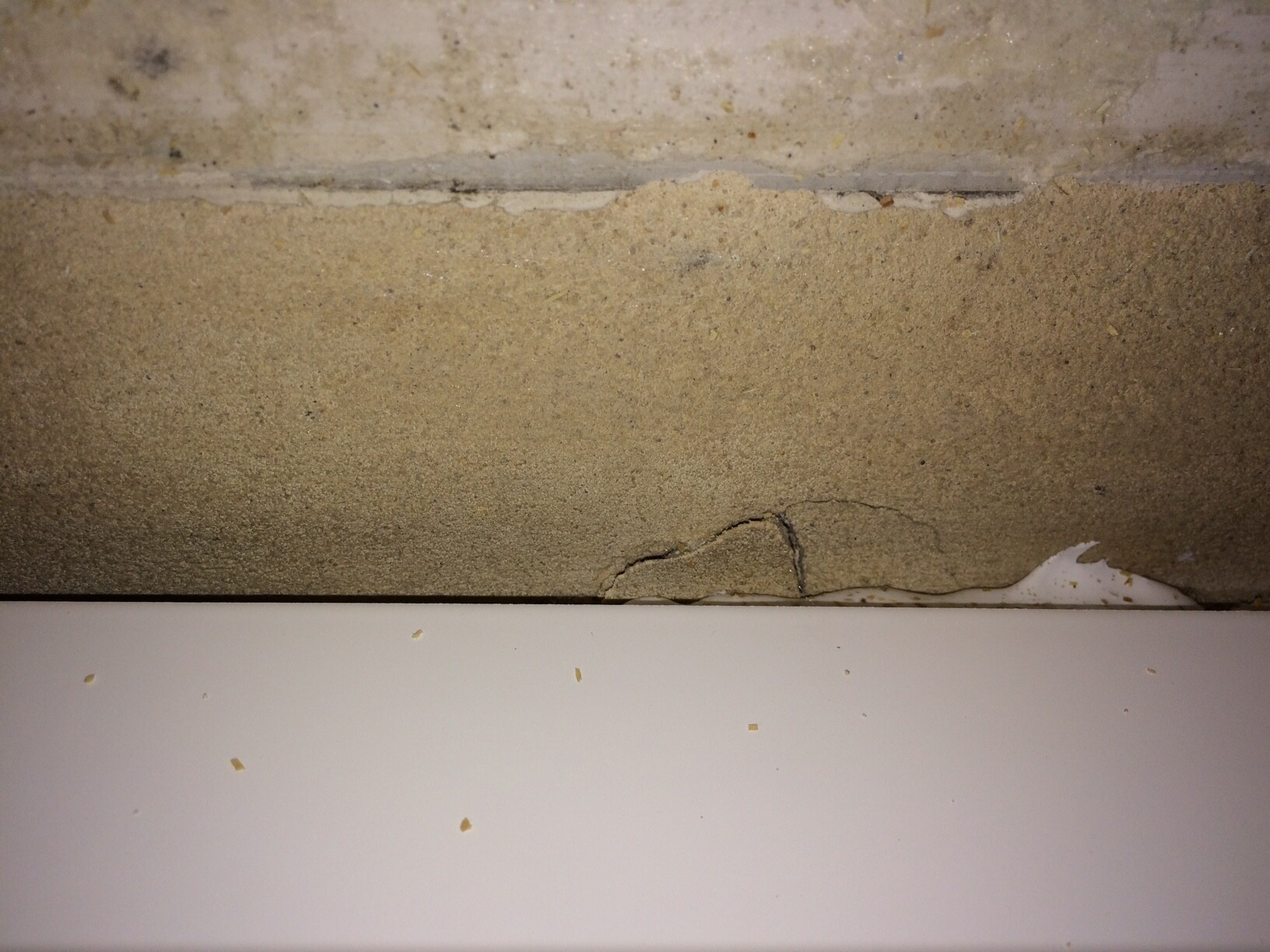 Kleine Risse in einer Fundamentwand mit rauem Untergrund sichtbar