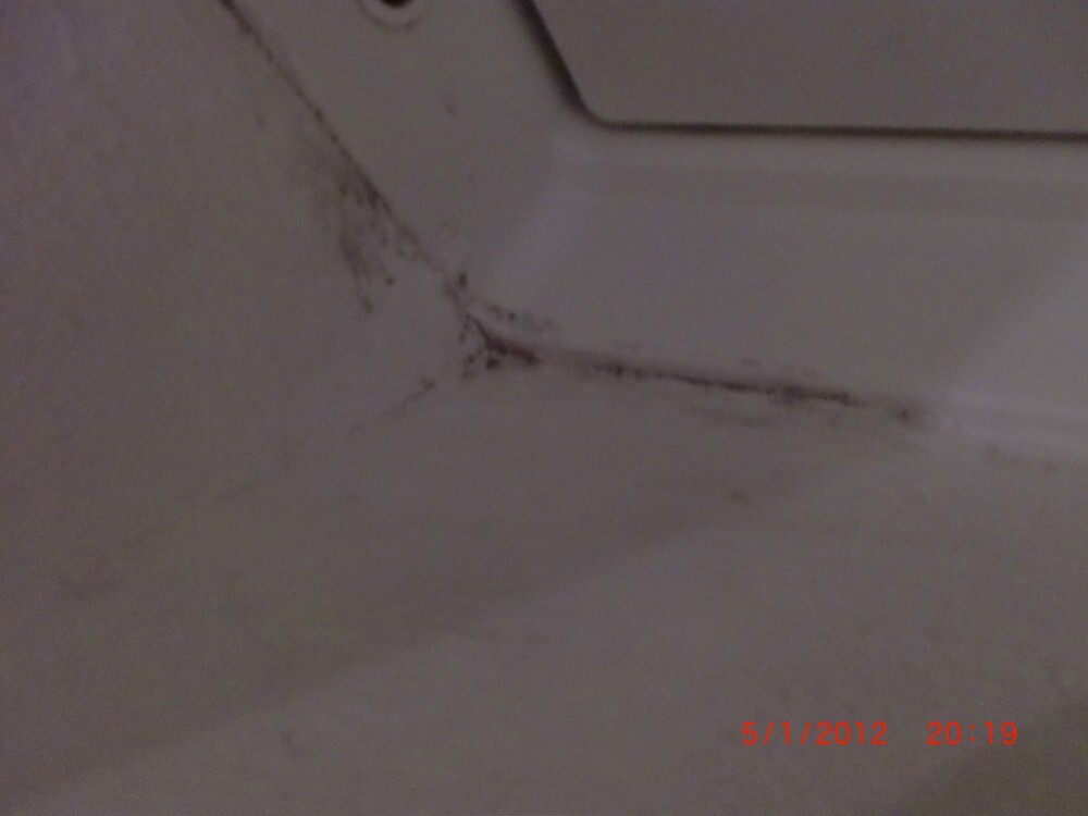 Schimmel- und Feuchtigkeitsspuren an der Wand- und Boden Ecke eines Badezimmers.