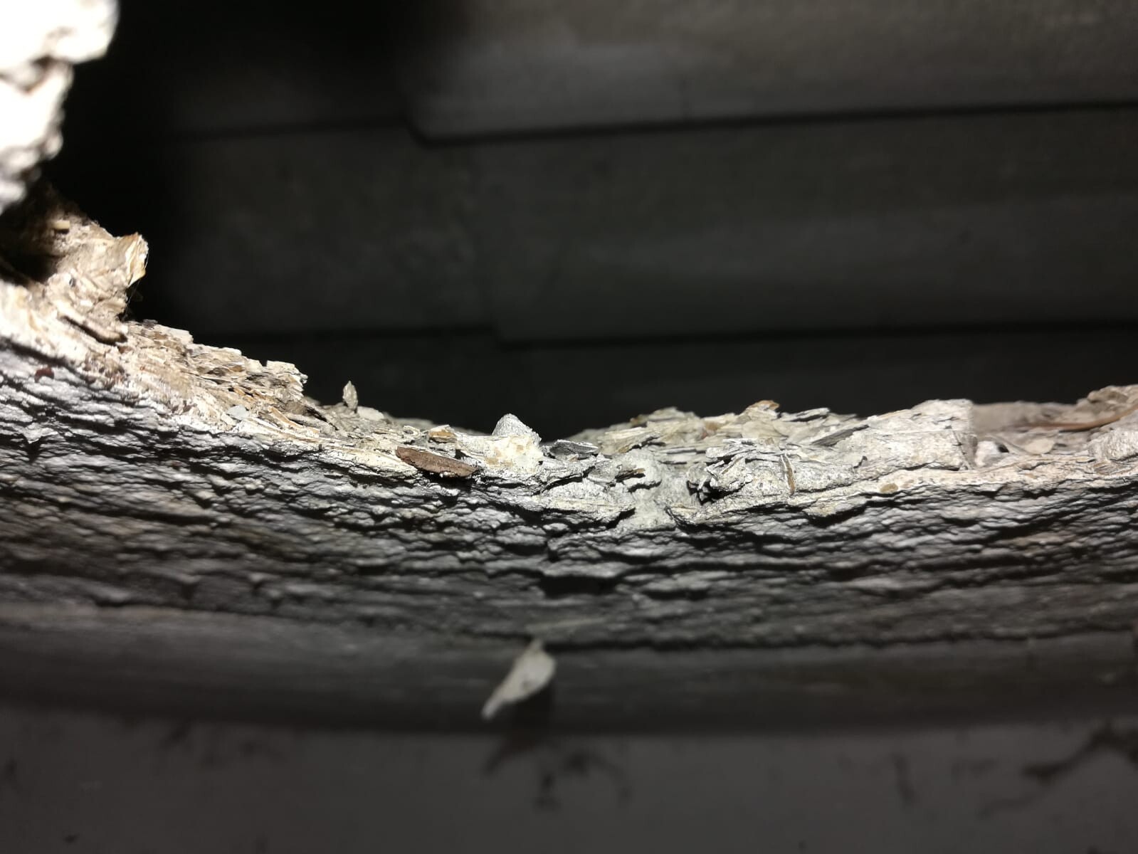 Nahaufnahme eines verrotteten Holzbalkens mit rauer Oberfläche in einer Baustruktur