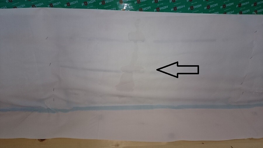 Wand mit unsauberer Naht, Pfeilmarkierung deutet auf Baumangel im Innenbereich