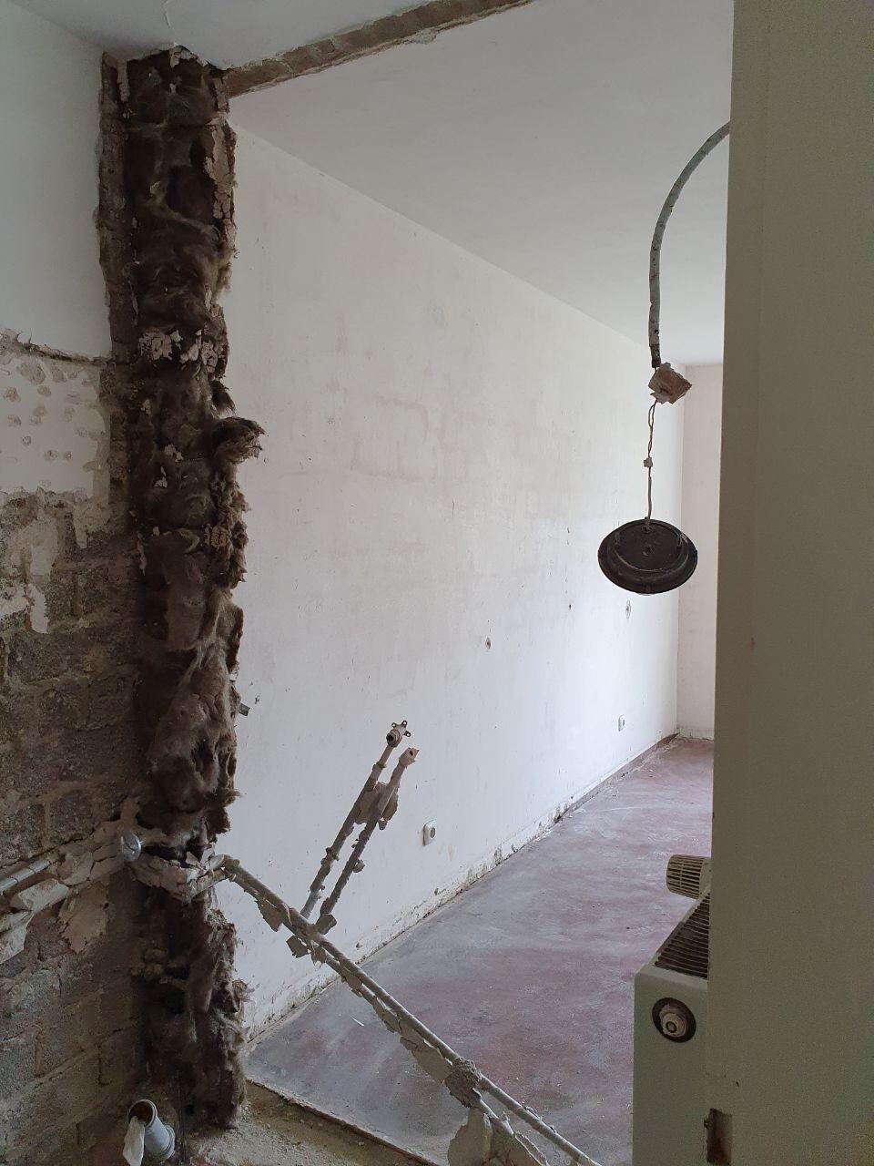 Innenraum im Bauzustand mit offener Wand, lose Mauern und schwebender Leuchte