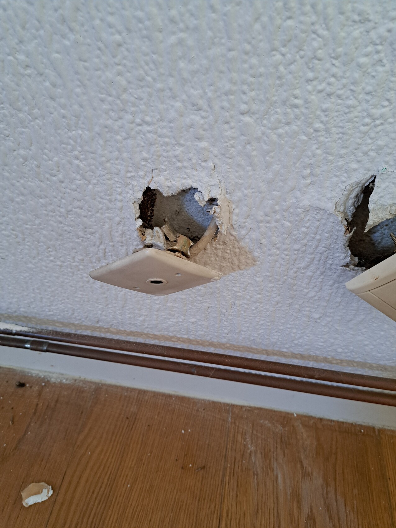 Decke mit Loch und losem Abdeckteil; freiliegende Kabel hängen heraus.
