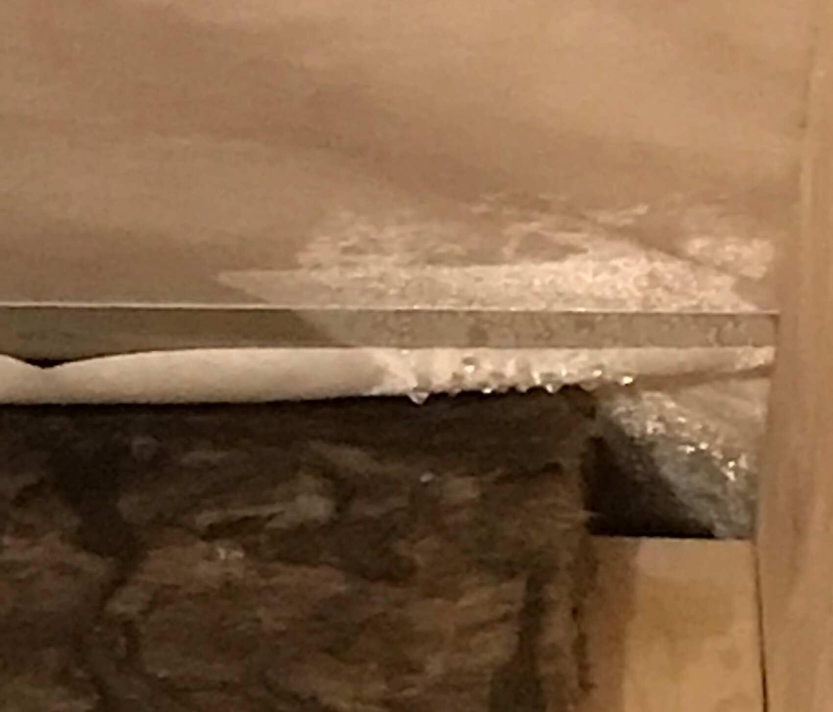 Nahaufnahme einer beschädigten Wand mit Putzabplatzungen an der Ecke