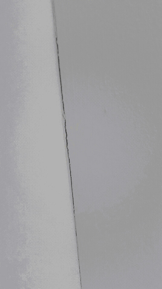 Nahaufnahme einer Innenwand mit sichtbarem Riss, Hinweis auf Baumängel.