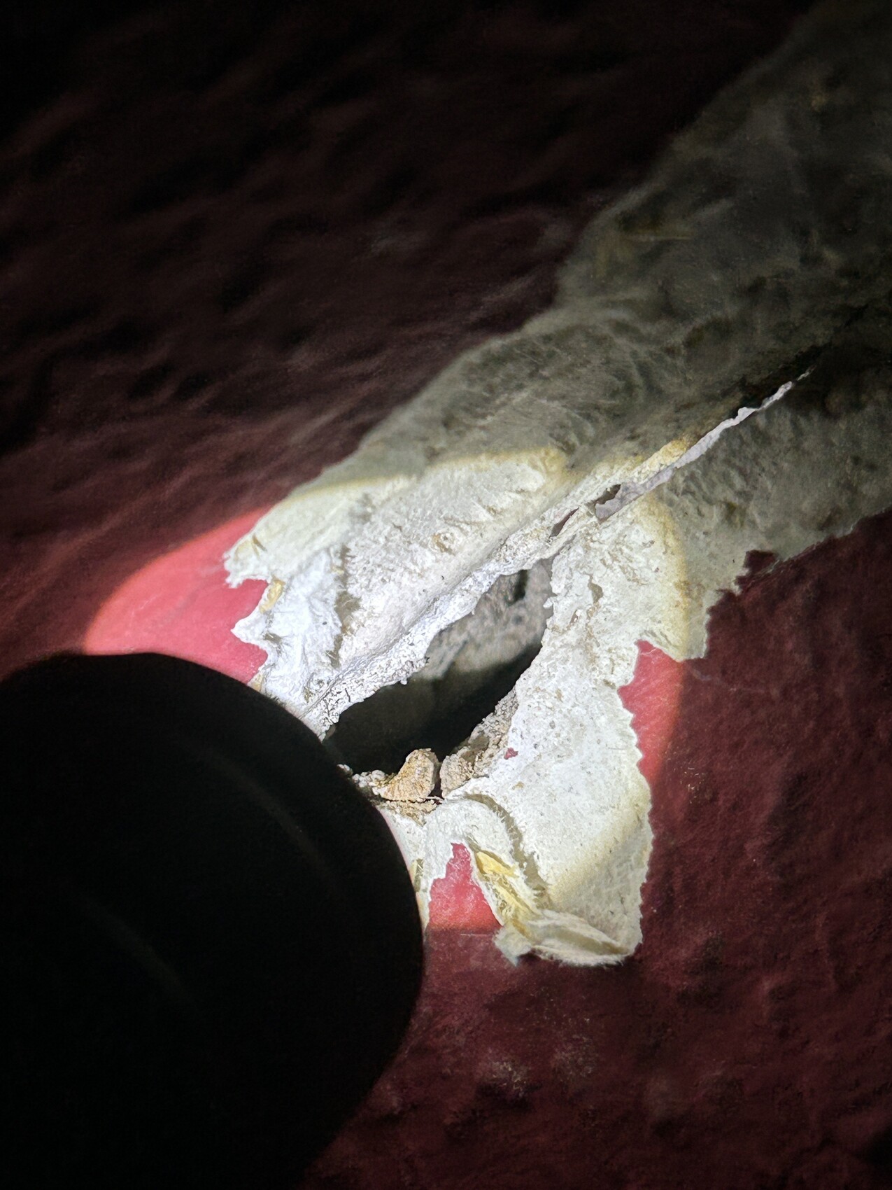 Abgenutzte Wand mit Putzrissen und Loch im Innenraum