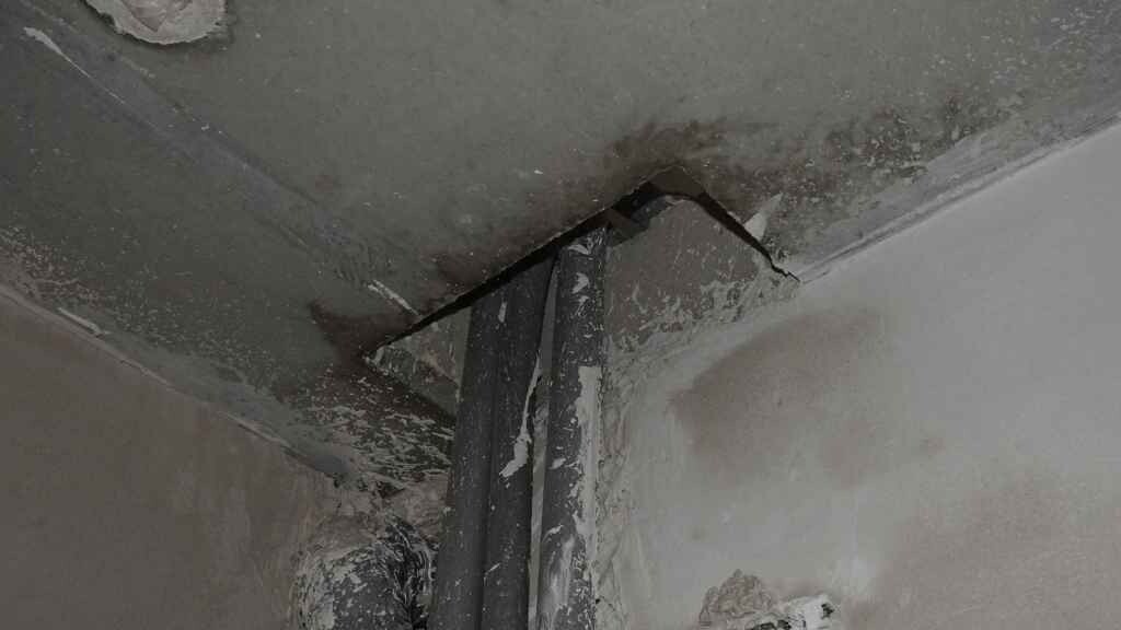 Baumängel: beschädigte Wand Ecke mit abplatzendem Putz und Bewehrung sichtbar