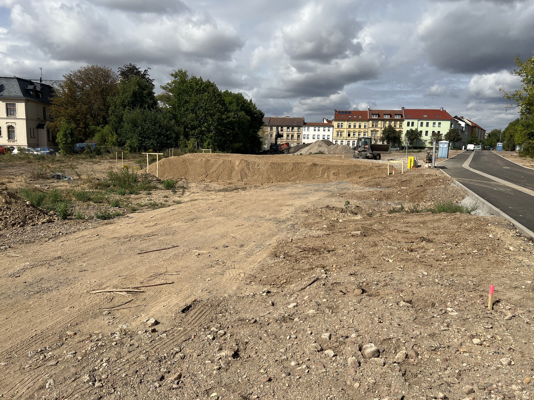 Baugebiet in der Stadt: Erdarbeiten, Bagger und Häuser im Hintergrund