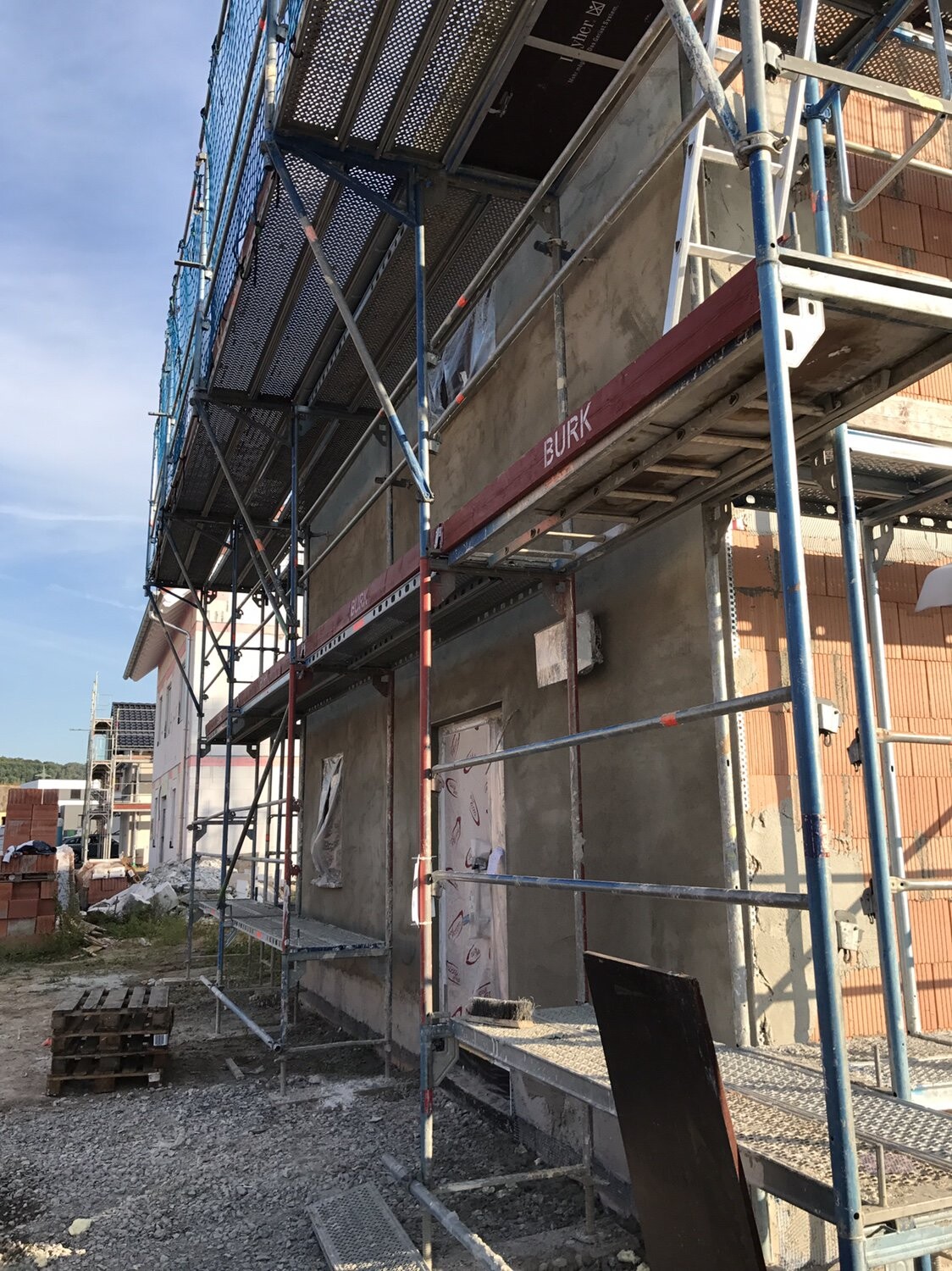 Baustelle mit Gerüst um Neubau; Fassadenbau und Bauarbeiten an der Außenwand