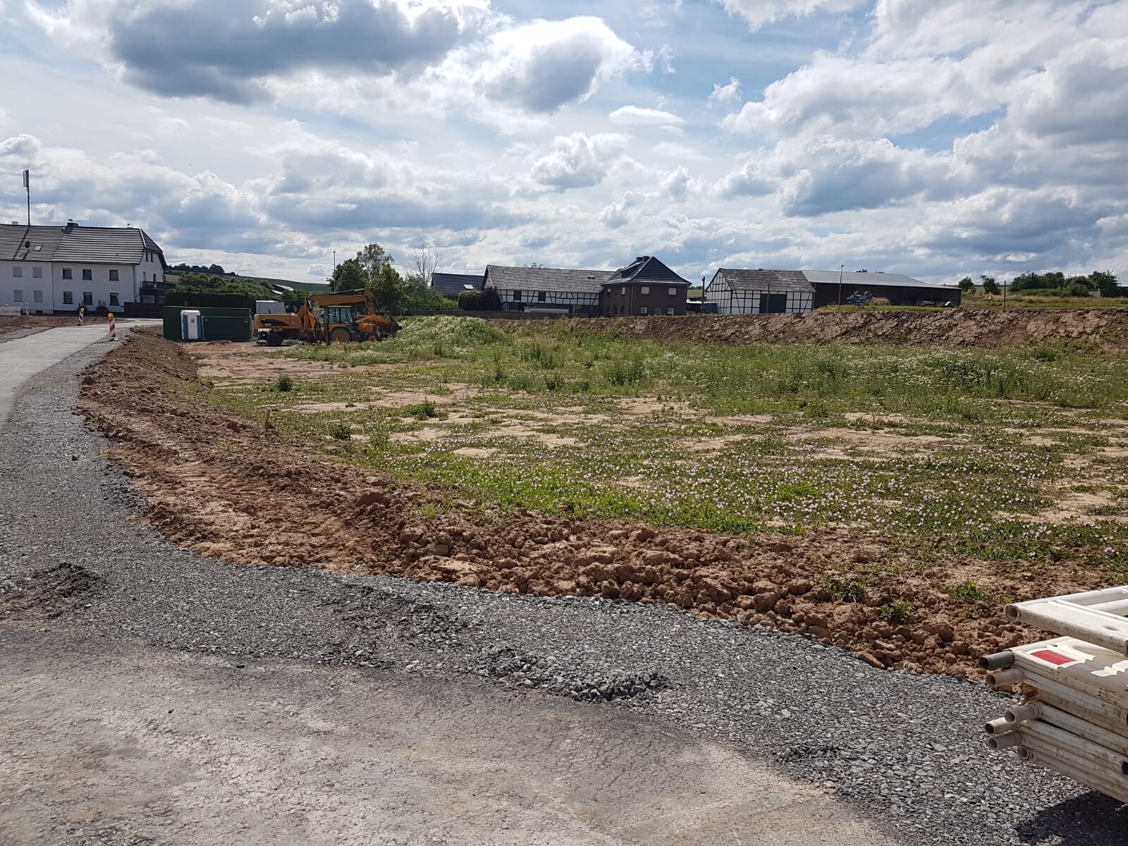 Baustelle mit Erdarbeiten, Baggern und Baugeräten auf freiem Grundstück