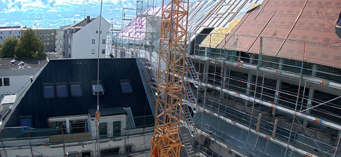 Baustelle mit Kran, Gerüst und Dacharbeiten an mehrstöckigem Gebäudekomplex