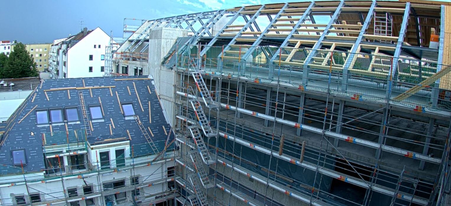 Mehrstöckiges Gebäude im Bau mit Gerüsten, Dachkonstruktion aus Holzrahmen und Bauzubehör.