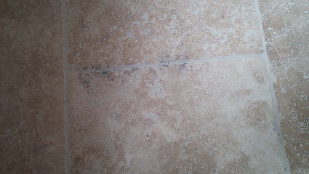 Beige Steinfliesenboden mit sichtbaren Fugenlinien.