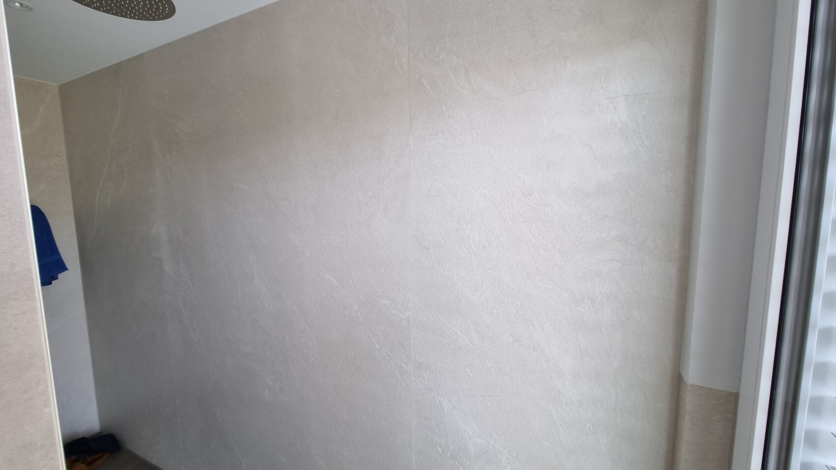 Beiges Badezimmer mit Dusche, Wandverkleidung aus Fliesen und seitlichem Fenster