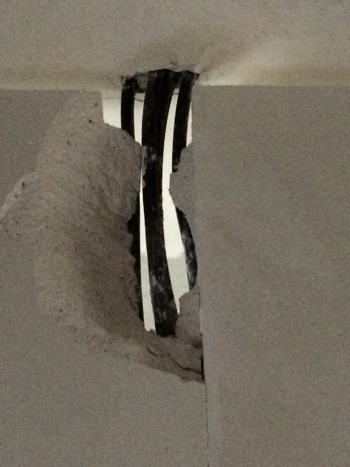 Wand mit Loch und freiliegenden Kabeln, Beschädigung sichtbar