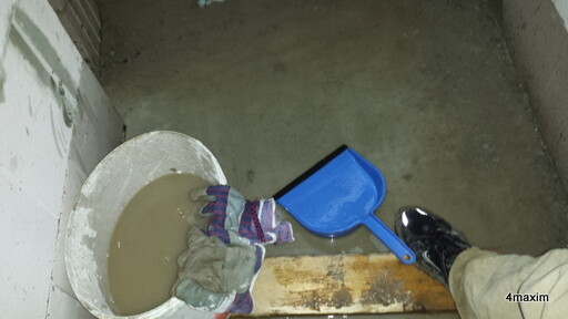 Baustelle mit feuchtem Beton, Handschuh und Schaufel.