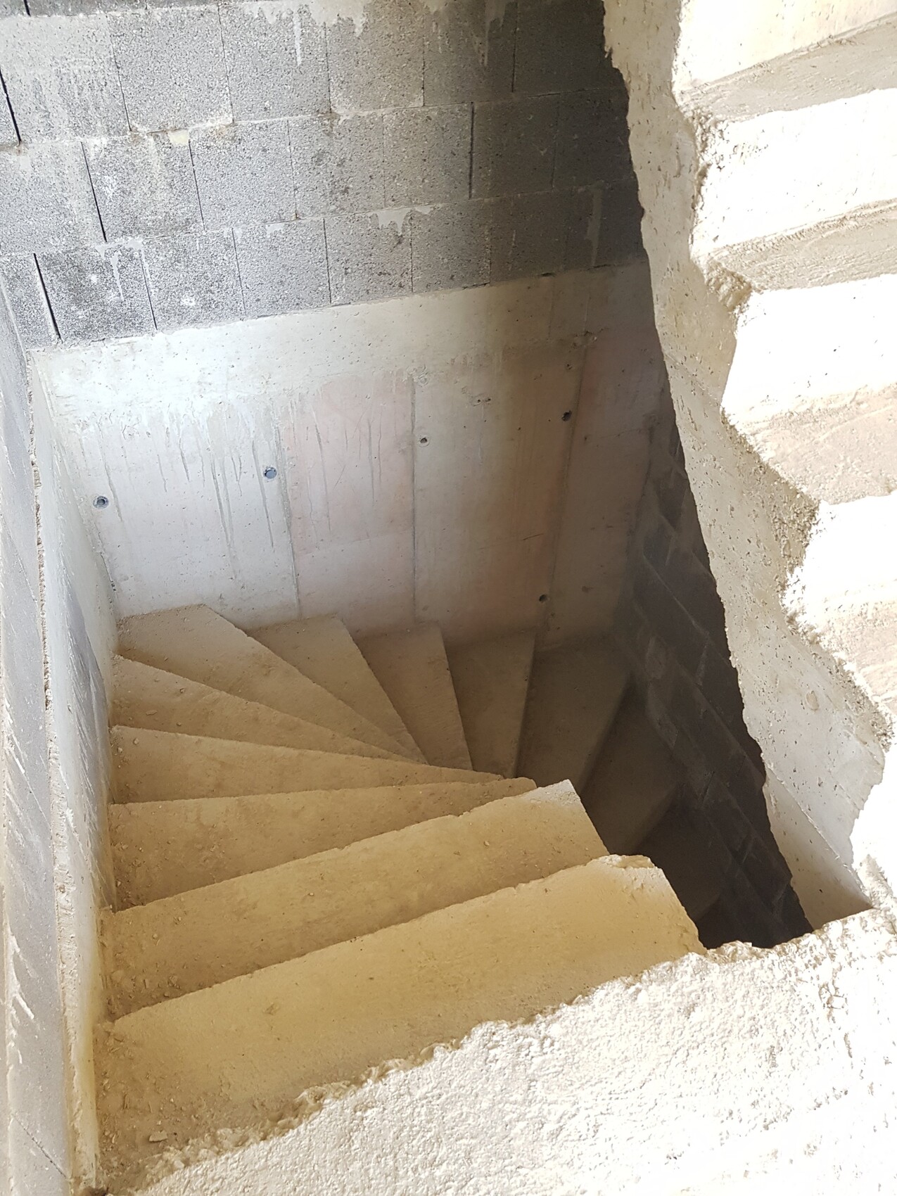 Rohbetontreppe im Kellergeschoss, unvollständige Wände, Baustellenzustand.