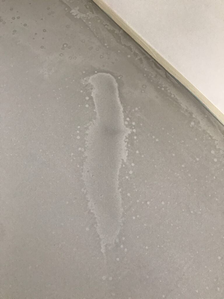Rohbetonboden im Innenraum mit deutlich sichtbarem Fußabdruck im Staub