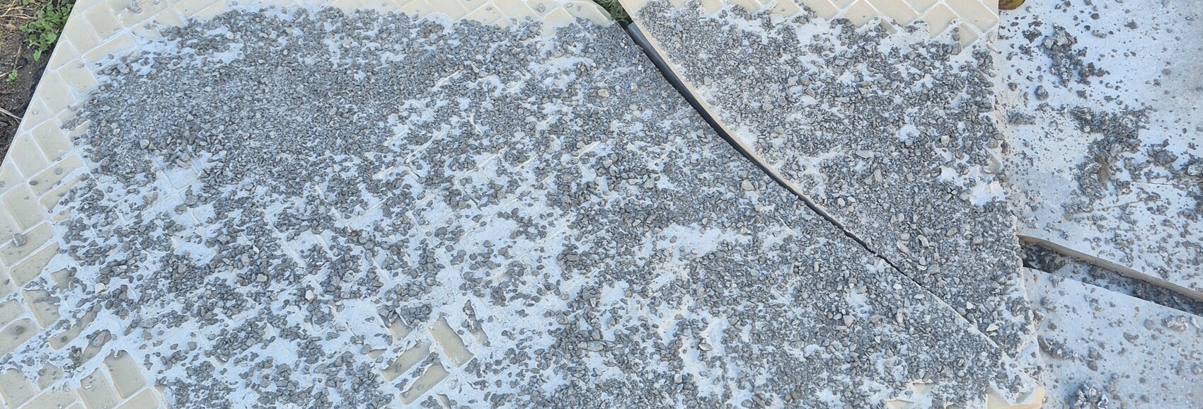 Betonboden mit Kies und Bruchkante auf Baustelle im Freien