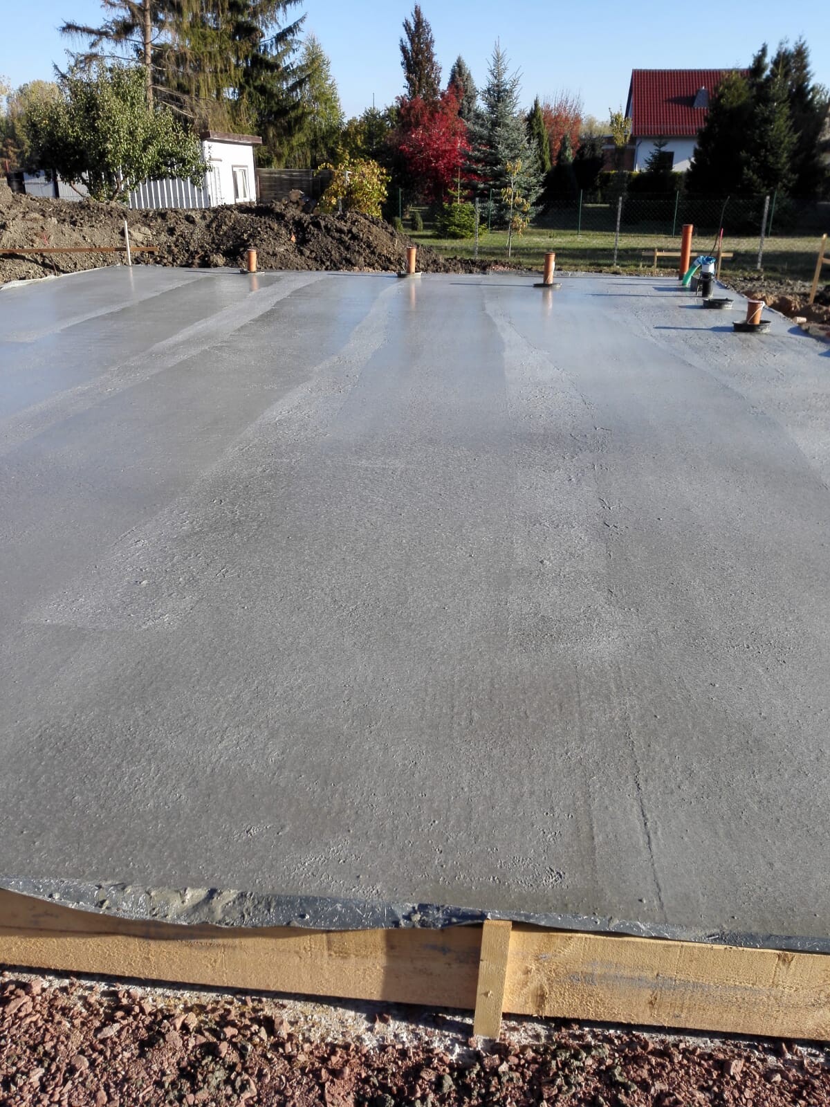 Frisch gegossene Betonbodenplatte auf einer Baustelle mit Holzformen