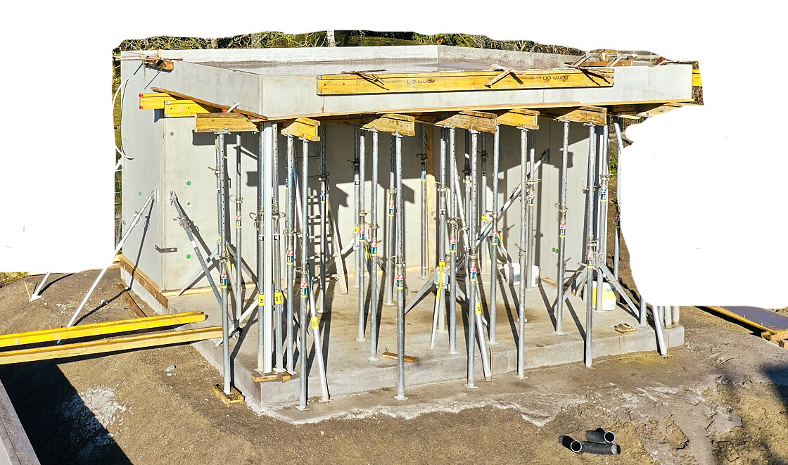 Betonformsatz mit vielen verstellbaren Stützstangen und Holzauflage auf Betonfundament.