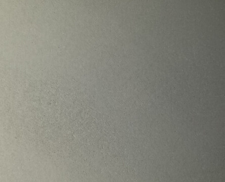 Nahaufnahme einer grauen Betonoberfläche mit feiner Struktur.