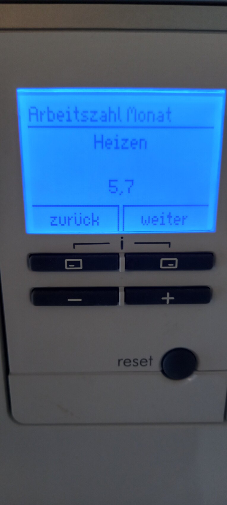 Blaues Display einer Heizungssteuerung zeigt Arbeitszahl Monat, Heizen, 5,7.