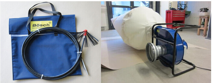 Links: blaue Werkzeugtasche mit aufgewickeltem Kabel; rechts Papierrolle und Kabelspule.