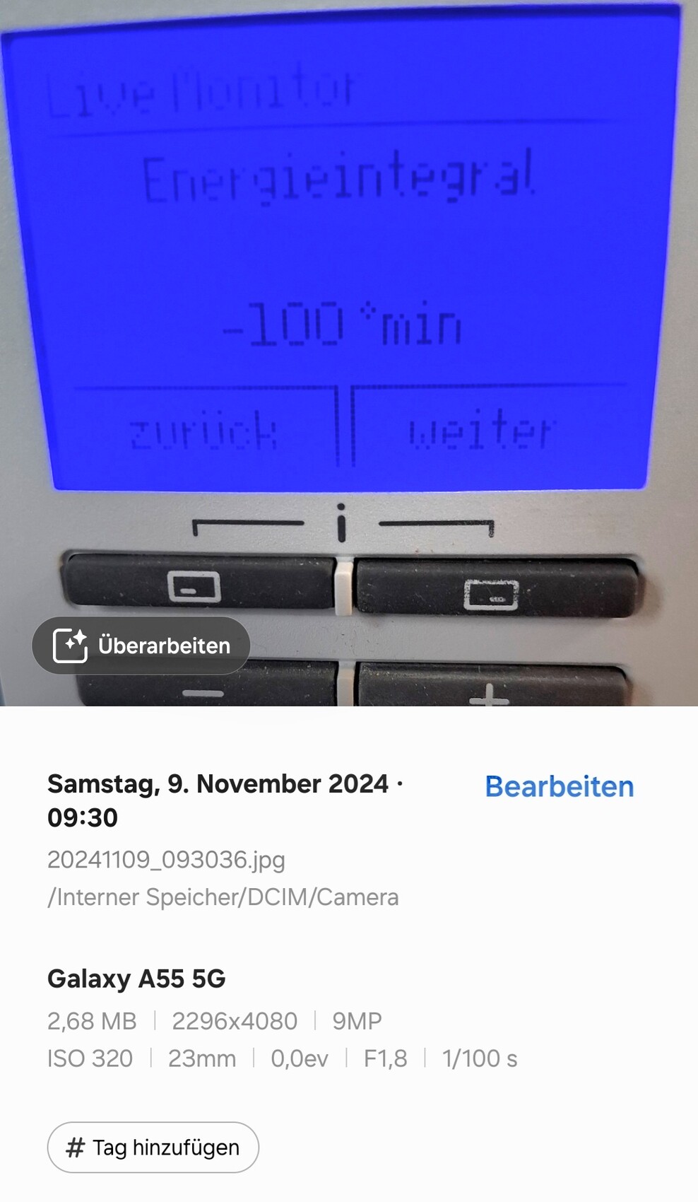 Blau beleuchtetes Display eines Geräts mit Live Monitor, Energiemodus, -100 min, Zurück/Weiter.