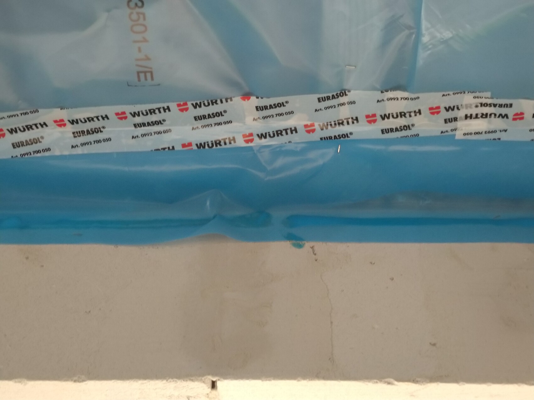 Blaue Baustellenfolie mit Wurth-Etiketten als Verpackungsmaterial auf einer Baustelle