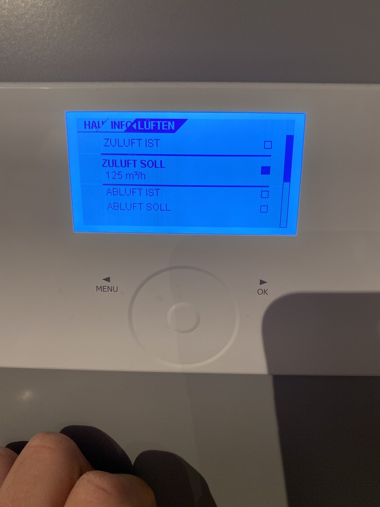 Blaues Display einer Lüftungsanlage: Zuluft Ist/Soll 125 m³/h, Abluft Ist/Soll.