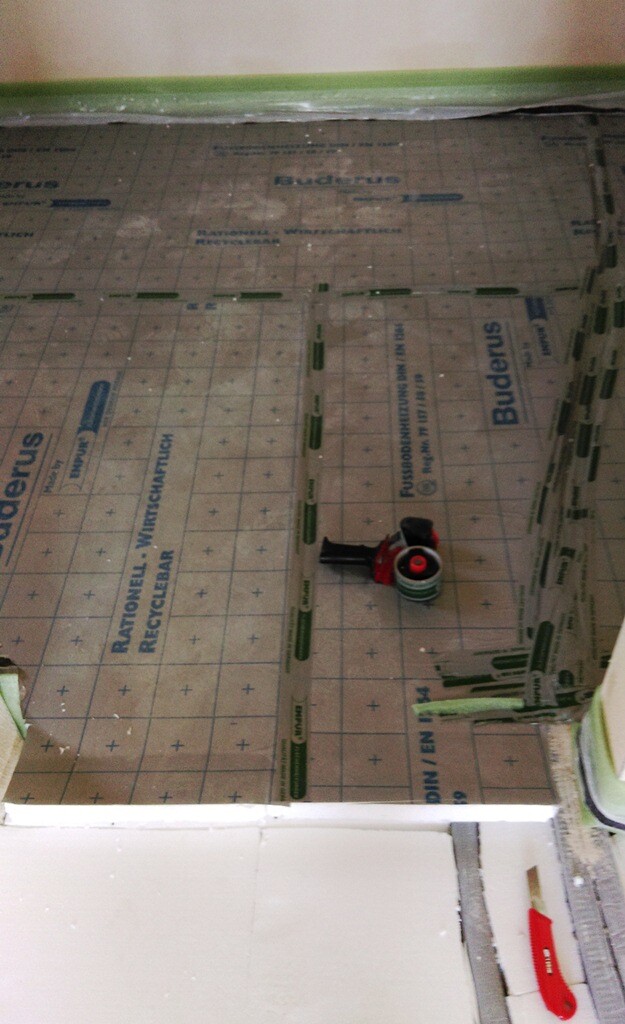 Badezimmer-Bodenaufbau: Bodenheizungselemente und Unterbodenplatten auf der Baustelle.