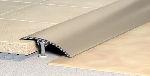 Übergangsprofil aus Metall zwischen Fliesen und Laminat, mit Schraubverankerung.
