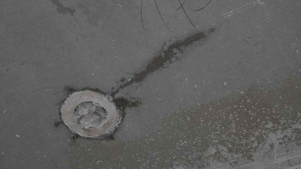 Runde Rohrdurchführung in rohem Betonboden einer Baustelle
