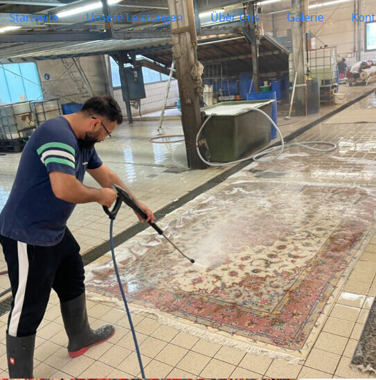 Mitarbeiter reinigt Teppichboden in Industriehalle mit Hochdruckreiniger