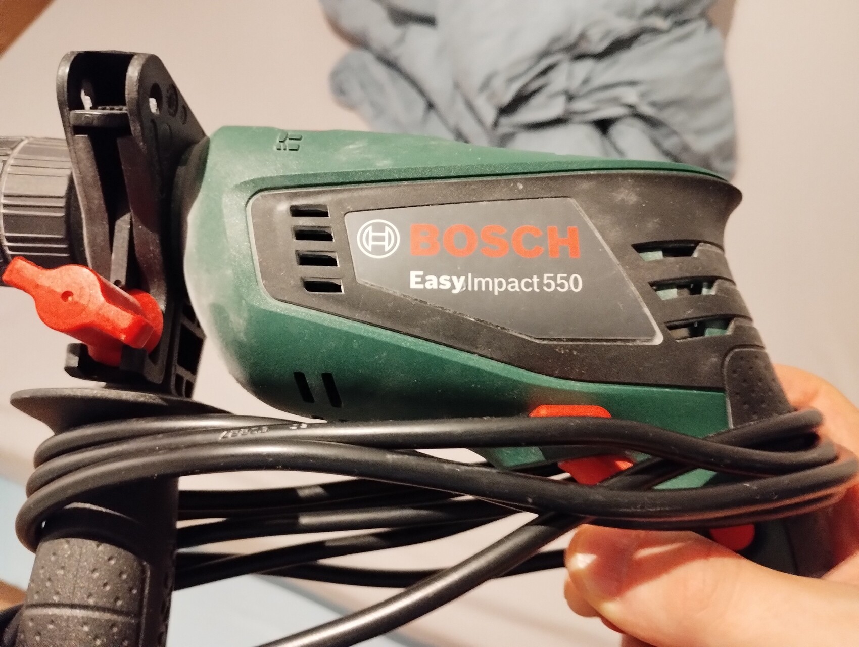 Bosch EasyImpact 550 Bohrhammer, grün-schwarz, mit Kabelwicklung um das Gerät.