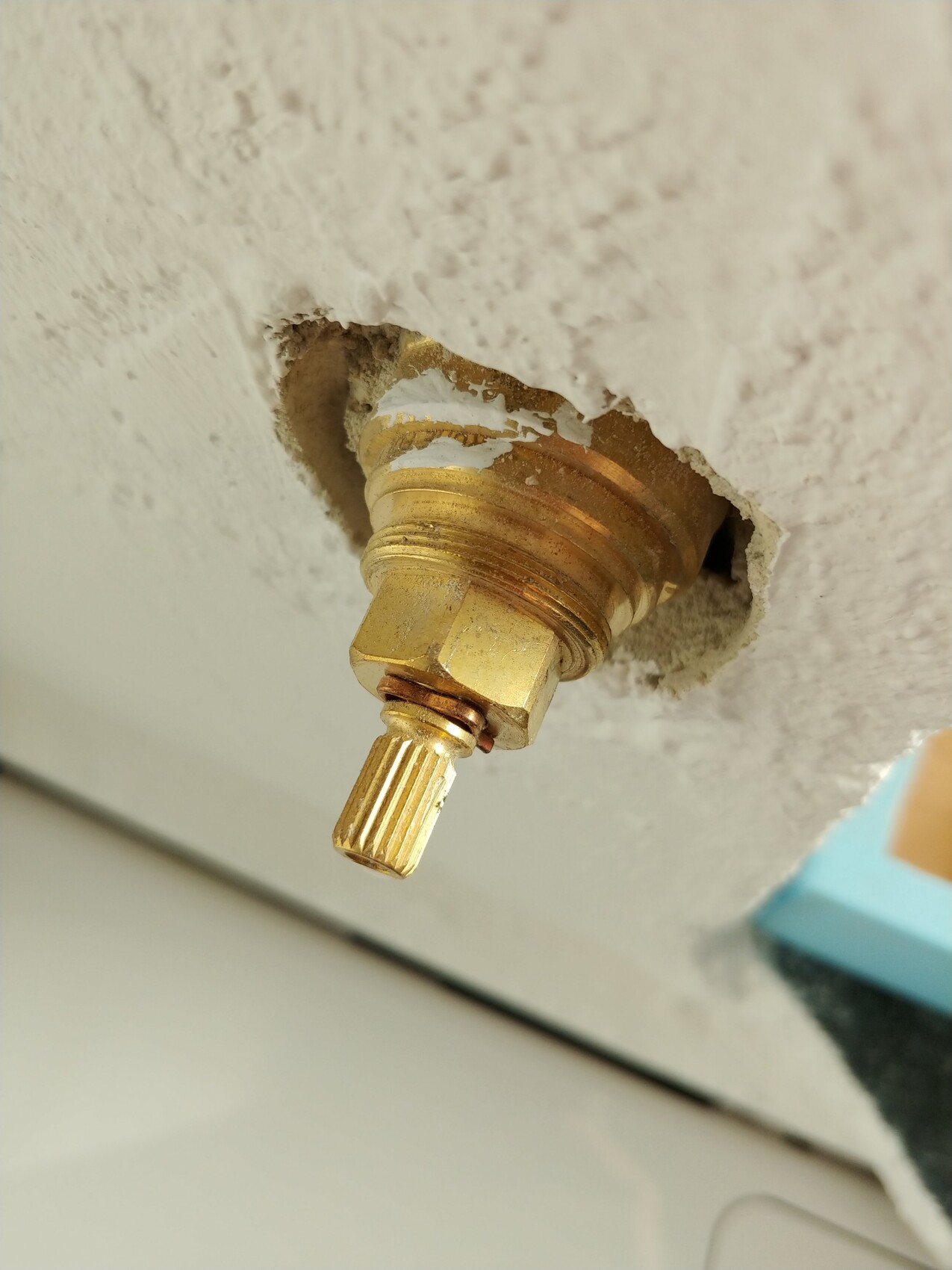 Nahaufnahme einer goldenen Sanitärarmatur in Wand mit Putz.