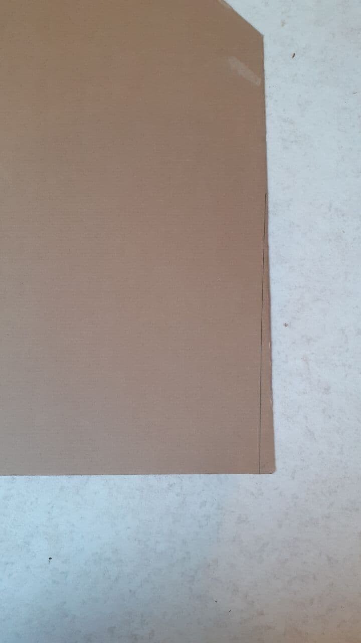 Braunes Kartonstück liegt flach auf hellem Betonboden.