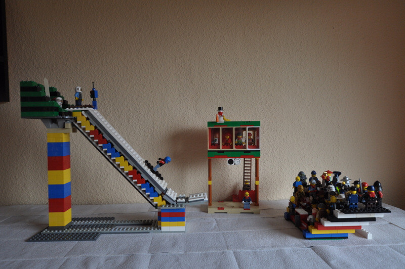 Bunte LEGO-Konstruktion mit Treppen, Turm und Minifiguren auf Spielbasis.