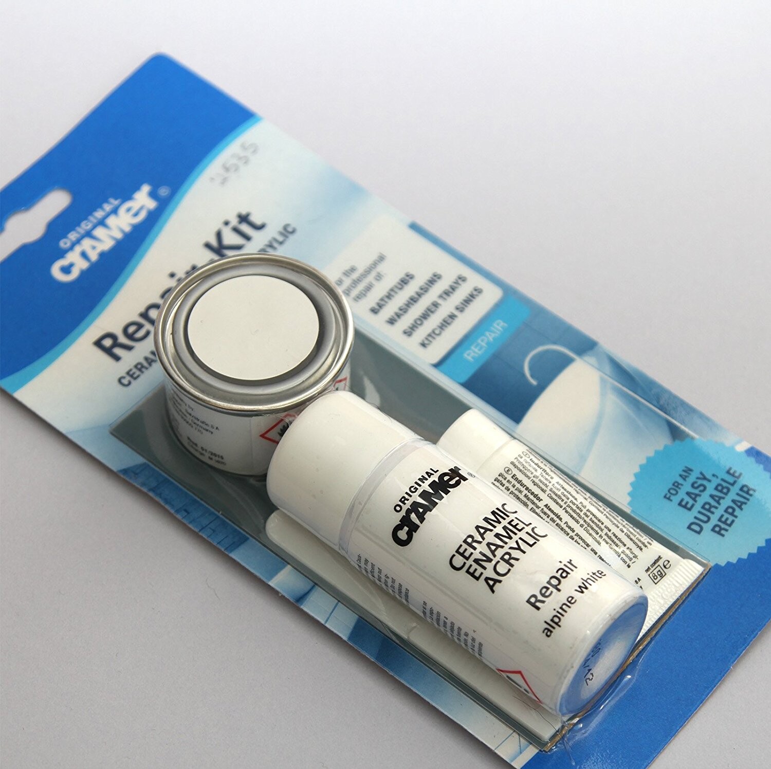 Keramik-Email-Reparaturset mit weißer Tube und kleiner Metalldose auf blauer Verpackung