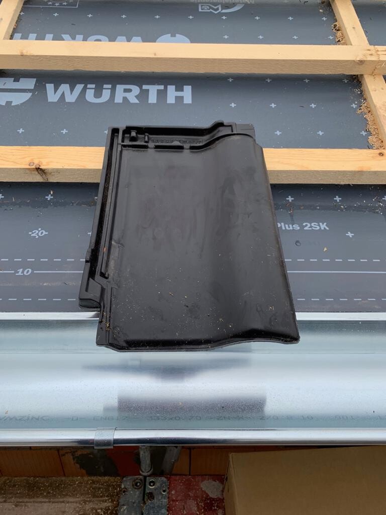 Schwarzes Kunststoff-Dachteil auf Dachbahn mit Holzlatten; WÜRTH-Logo sichtbar.