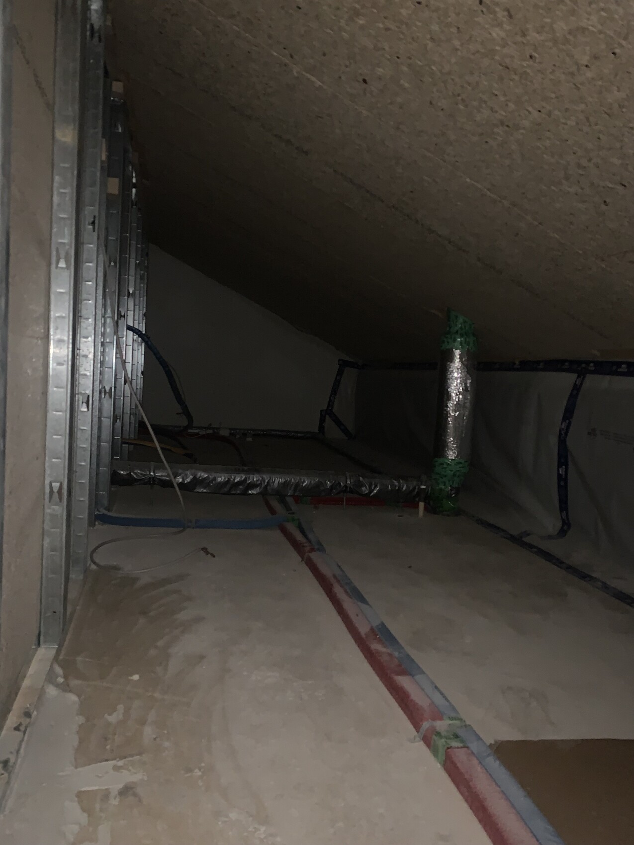Dachboden-Bauinstallation mit Rohren, Dämmung und isolierten Kanälen sichtbar